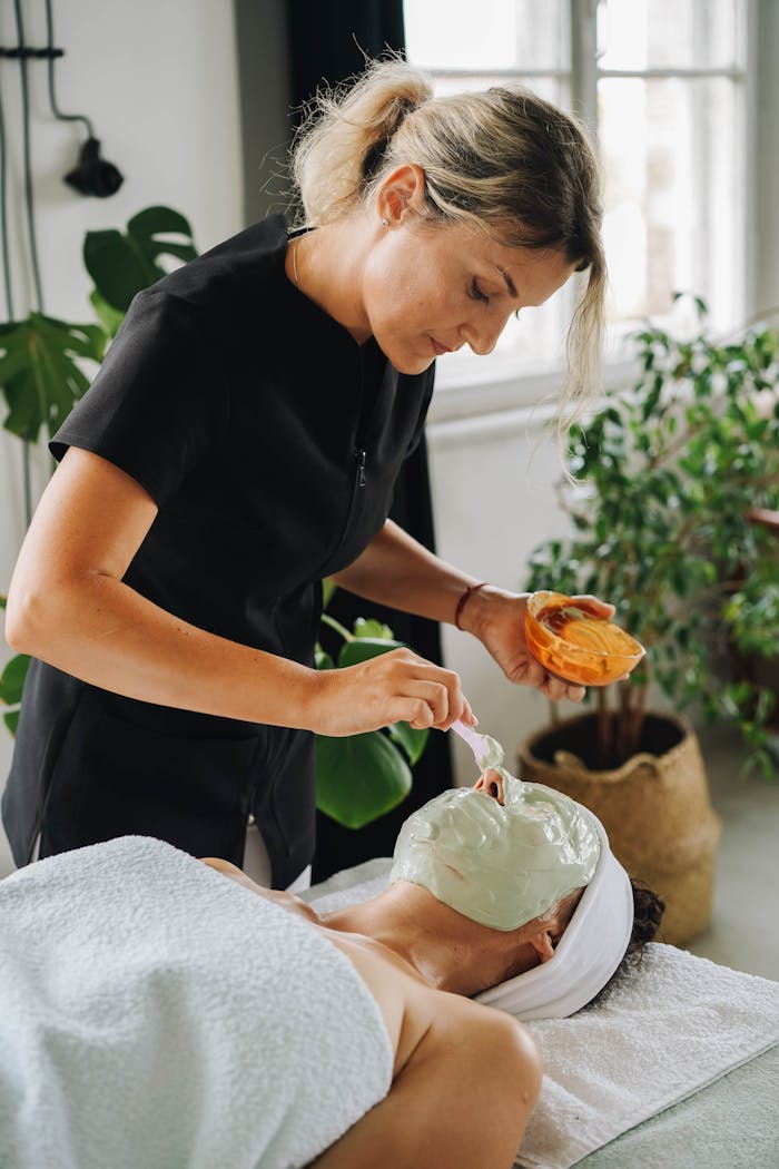 Aesthetician applying a soothing facial mask in a tranquil spa setting.